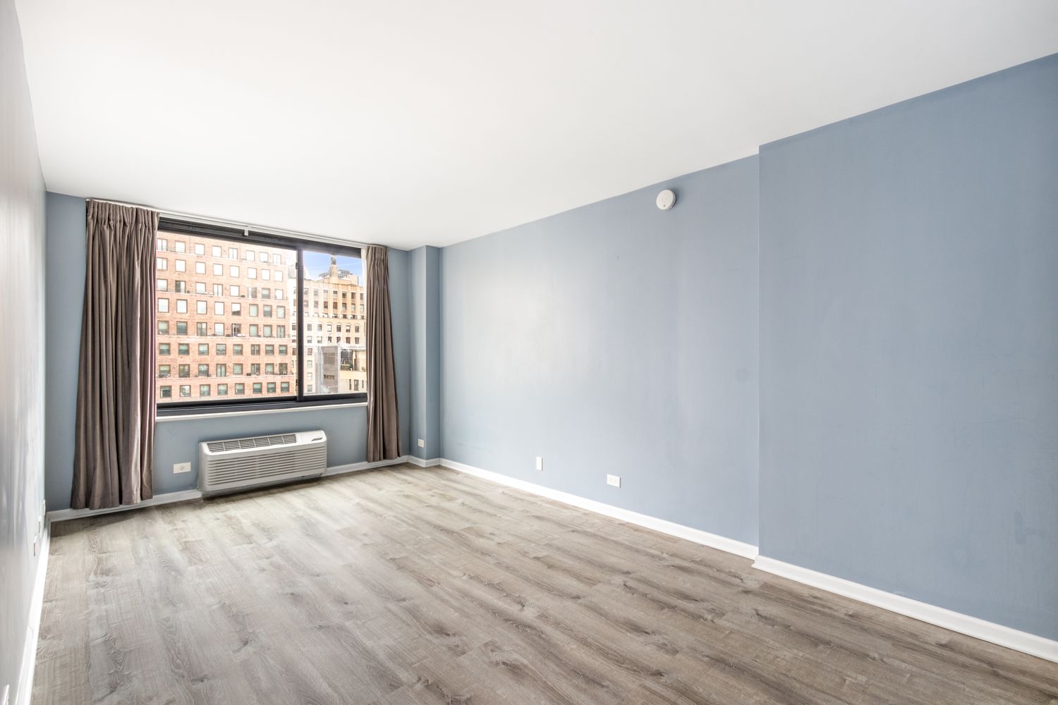 111 East 30th Street, Unit 14A Manhattan, NY 10016 - Photo 6 of 16 an empty room with wooden floor and windows