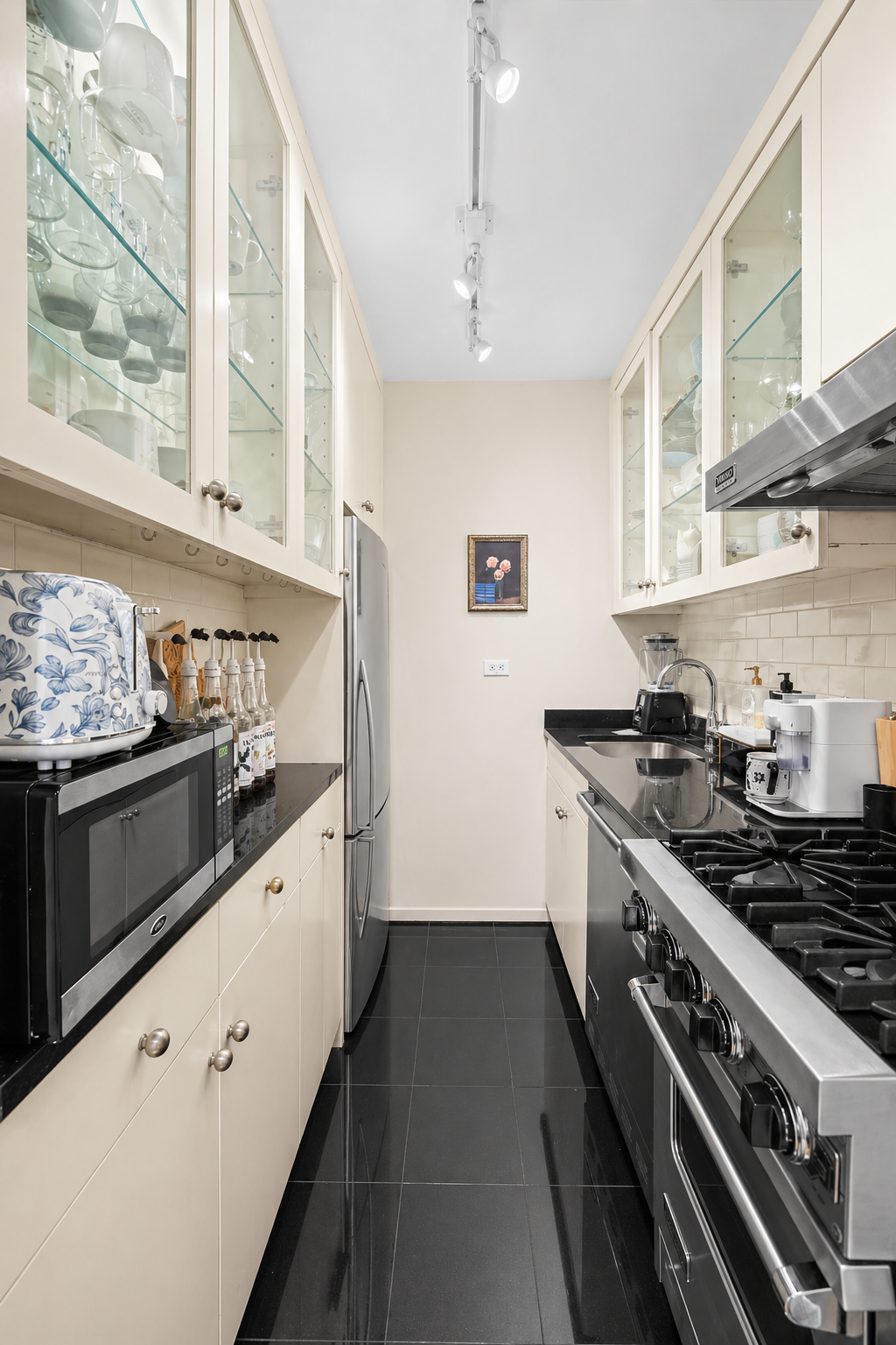 1175 York Avenue, Unit 1K Manhattan, NY 10065 - Photo 4 of 10 a kitchen with stainless steel appliances granite countertop a stove and a sink