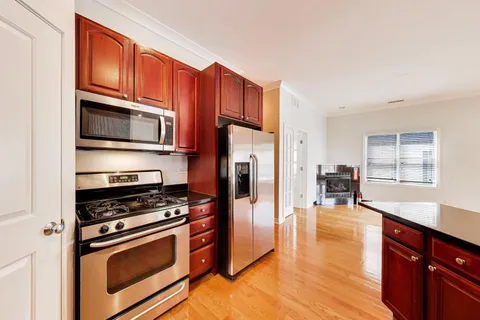 a kitchen with stainless steel appliances a stove a microwave and wooden cabinets