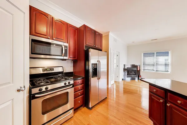 a kitchen with stainless steel appliances a stove a microwave and wooden cabinets