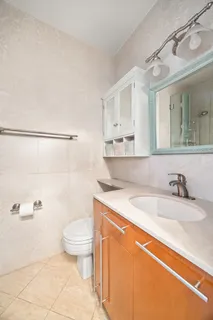 a bathroom with a granite countertop sink a toilet and a mirror