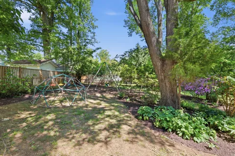 a backyard of a house with lots of green space and fountain