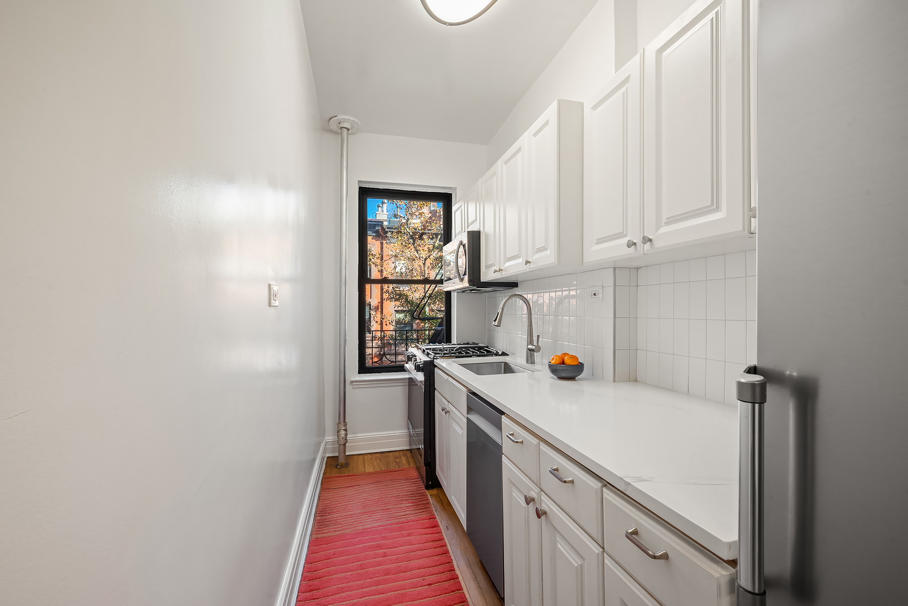 124 East 91st Street, Unit 3D Manhattan, NY 10128 - Photo 4 of 11 a view of a kitchen with a window