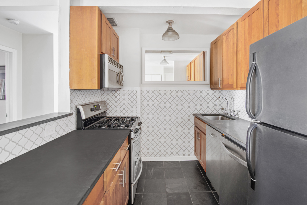 72 East 3rd Street, Unit 5A Manhattan, NY 10003 - Photo 5 of 16 a kitchen with a stove a sink and a refrigerator