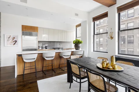 a kitchen with a dining table chairs and window