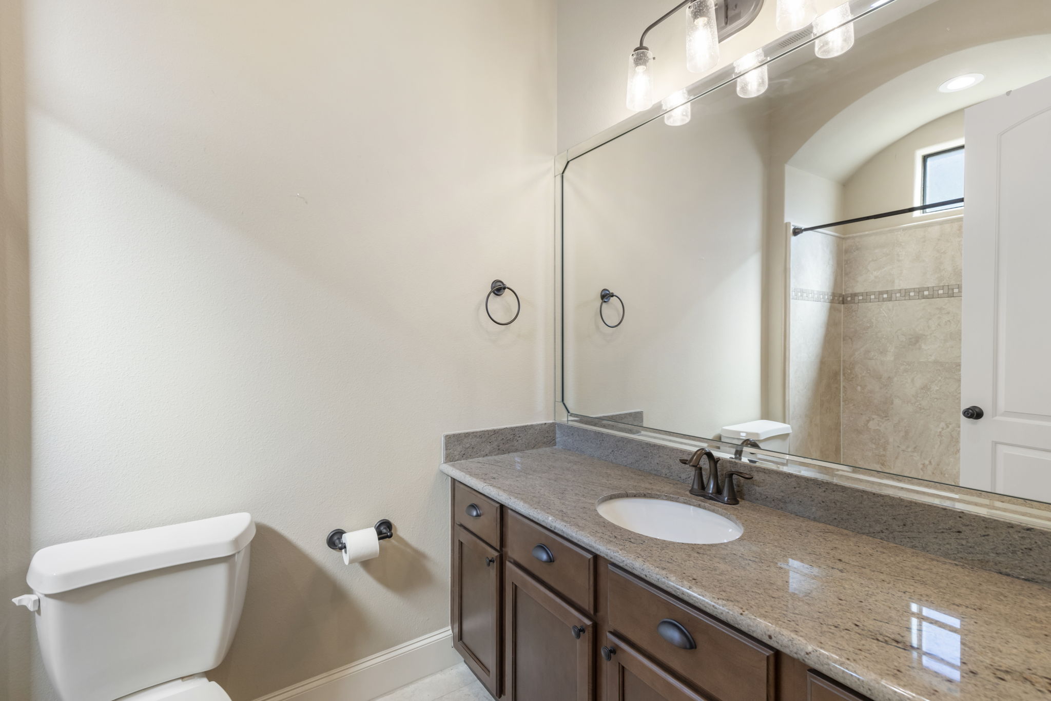 5407 Feagan Street Houston, TX 77007 - Photo 28 of 43 a bathroom with a granite countertop sink a toilet and a mirror