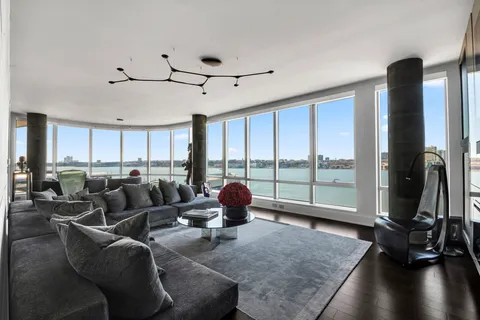 a living room with furniture gym equipment and a large window