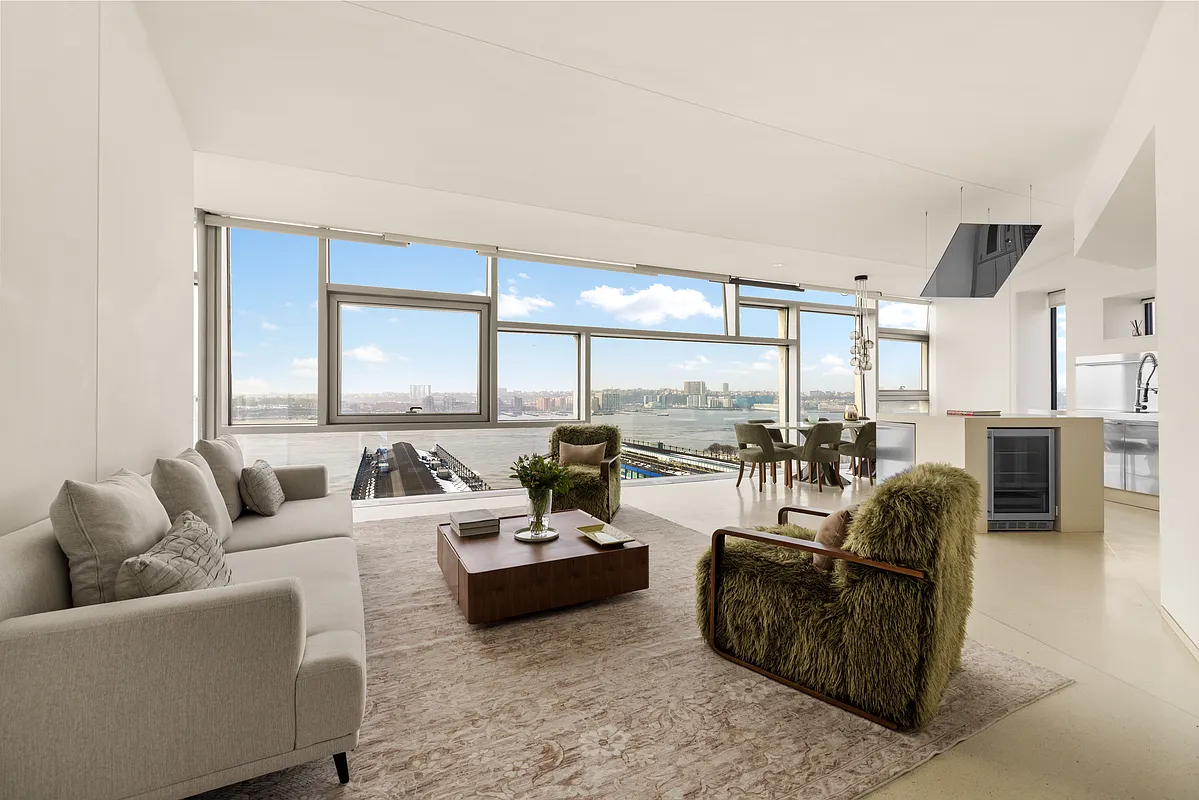 a living room with furniture and three large window