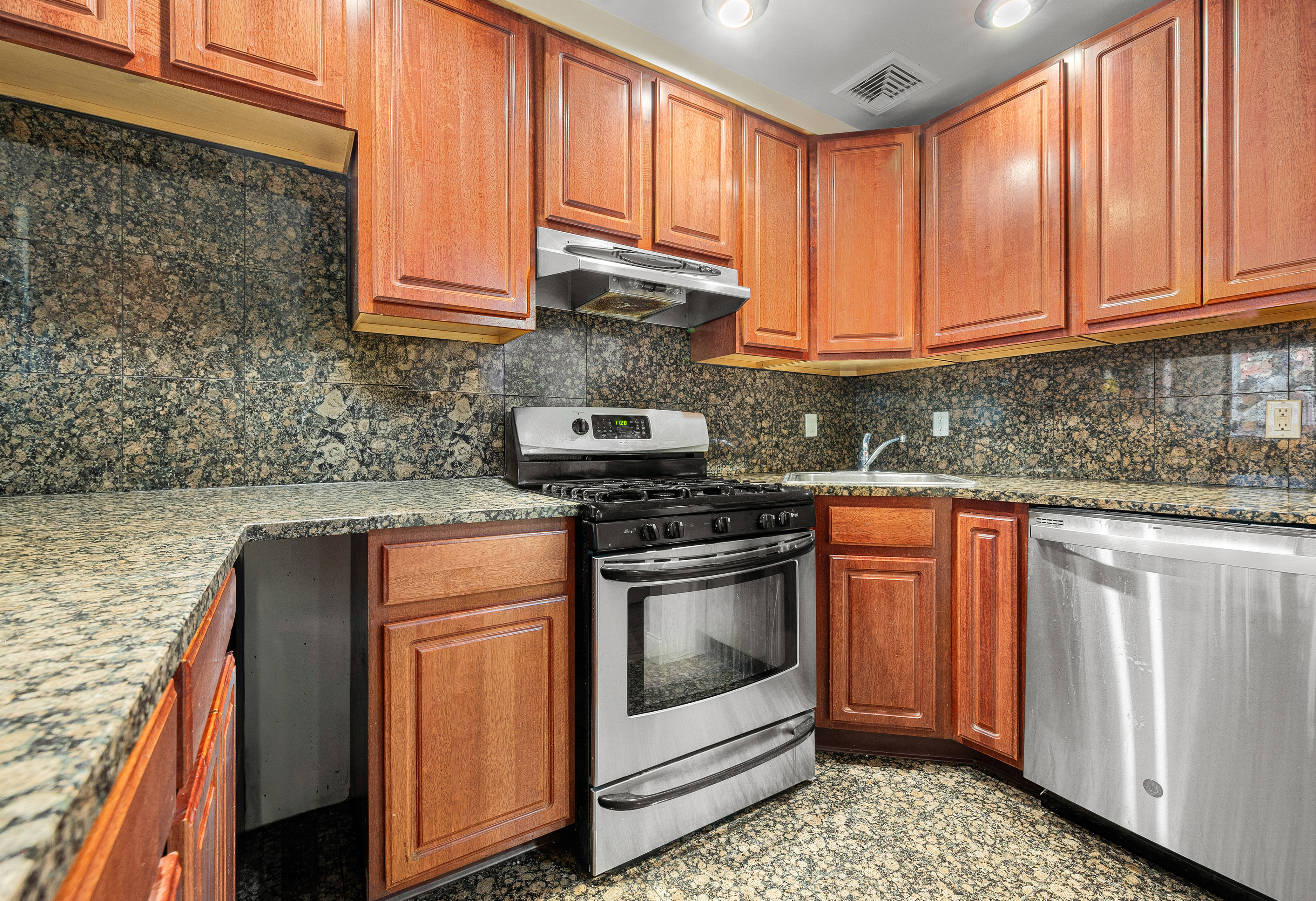 518 West 149th Street Manhattan, NY 10031 - Photo 6 of 23 a kitchen with stainless steel appliances granite countertop a stove a sink and a microwave