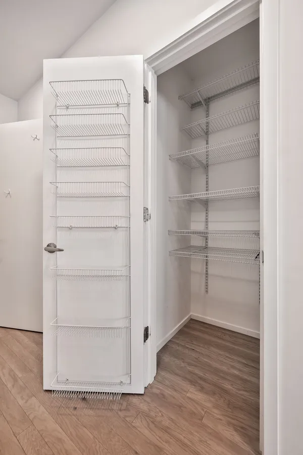 a view of walk in closet with empty racks