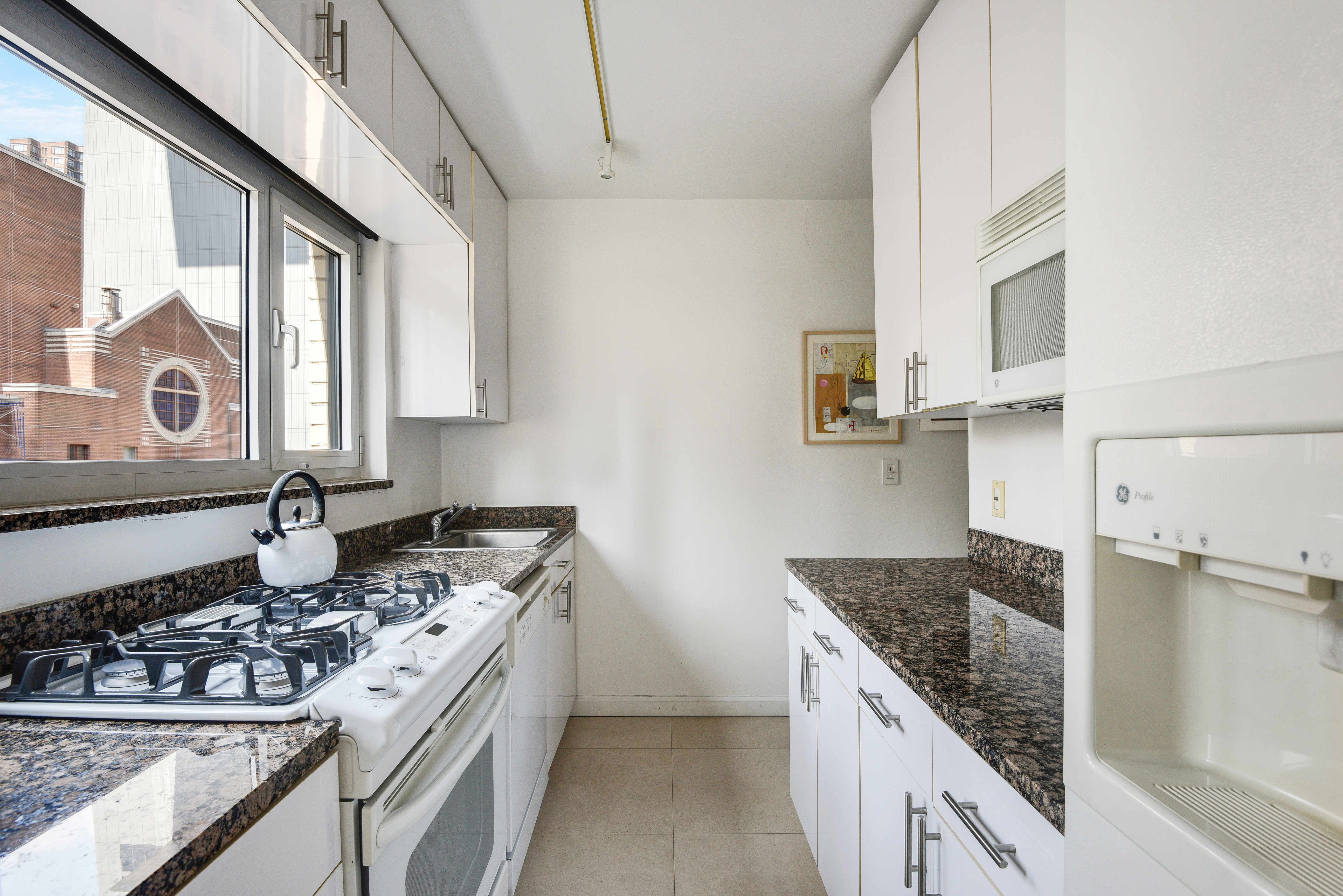 200 Central Park South, Unit 19J Manhattan, NY 10019 - Photo 10 of 12 a kitchen with stainless steel appliances granite countertop a stove and a sink
