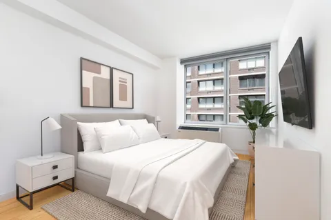 a bedroom with a large bed a flat screen tv and a book shelf