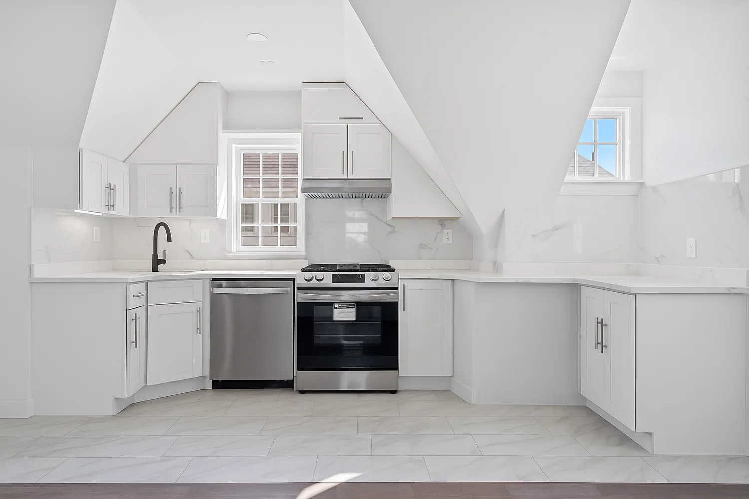 a kitchen with stainless steel appliances a stove and white cabinets