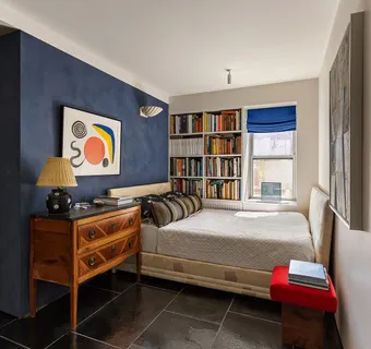 a bedroom with a bed and a bookshelf