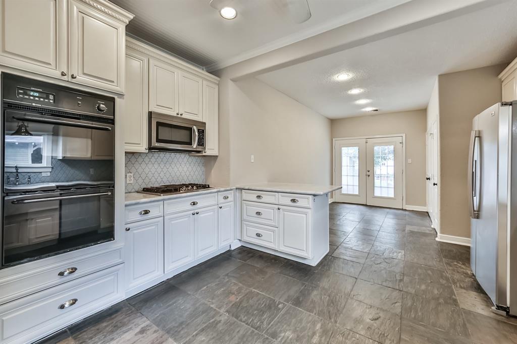 1120 Winston Street Houston, TX 77009 - Photo 11 of 29 a kitchen with stainless steel appliances granite countertop a stove a sink and a microwave
