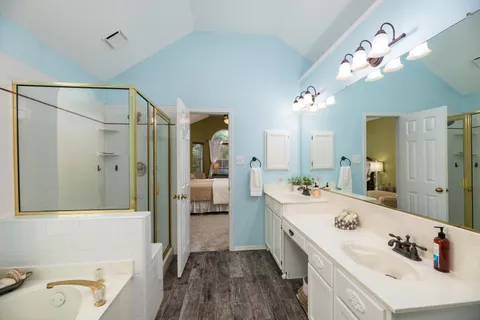 a bathroom with a tub sink and mirror