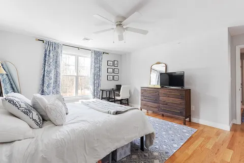 a bedroom with a bed and wooden floor