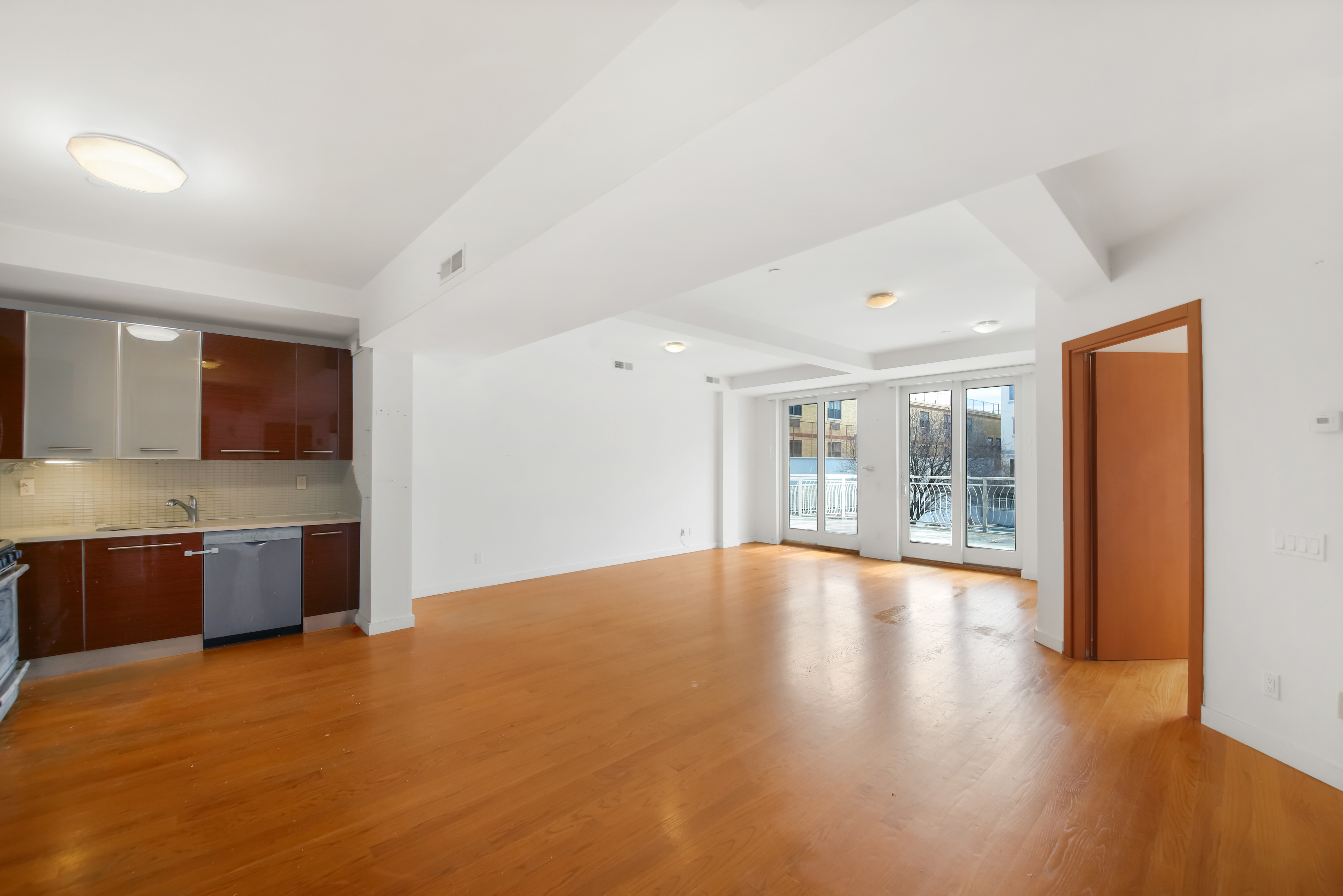 3112 Emmons Avenue, Unit 107 Brooklyn, NY 11235 - Photo 6 of 14 a view of an empty room with window and wooden floor