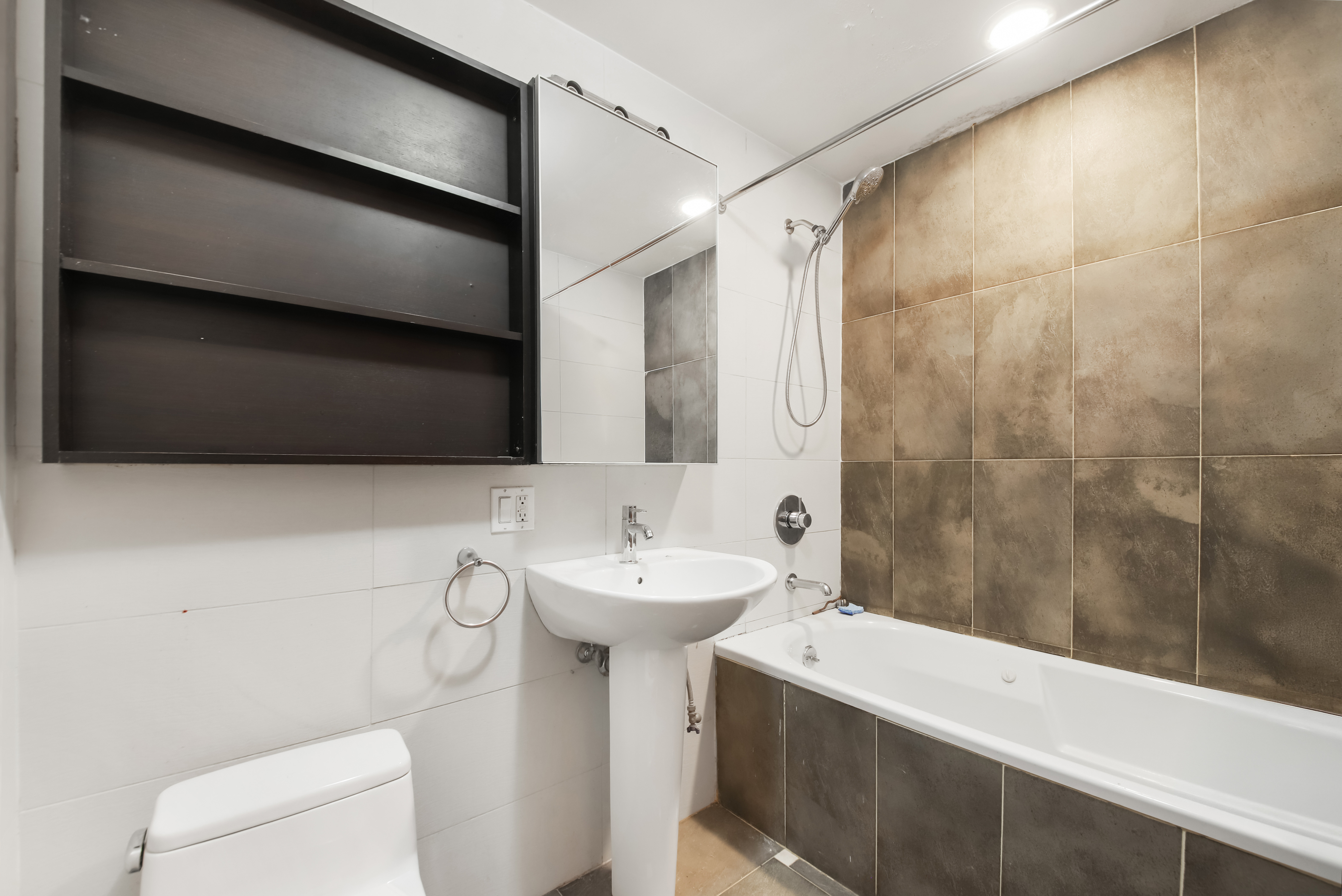 3112 Emmons Avenue, Unit 107 Brooklyn, NY 11235 - Photo 10 of 14 a bathroom with a sink a toilet and shower