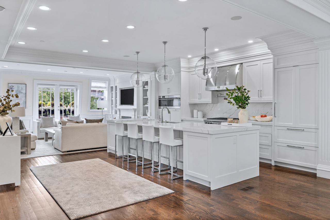 361 Beacon Street, Unit PH Boston, MA 02116 - Photo 4 of 9 a large white kitchen with kitchen island a stove a sink a couch and a dining table with wooden floor