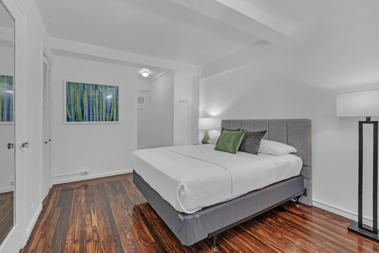 a bedroom with a bed and wooden floor