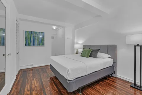 a bedroom with a bed and wooden floor