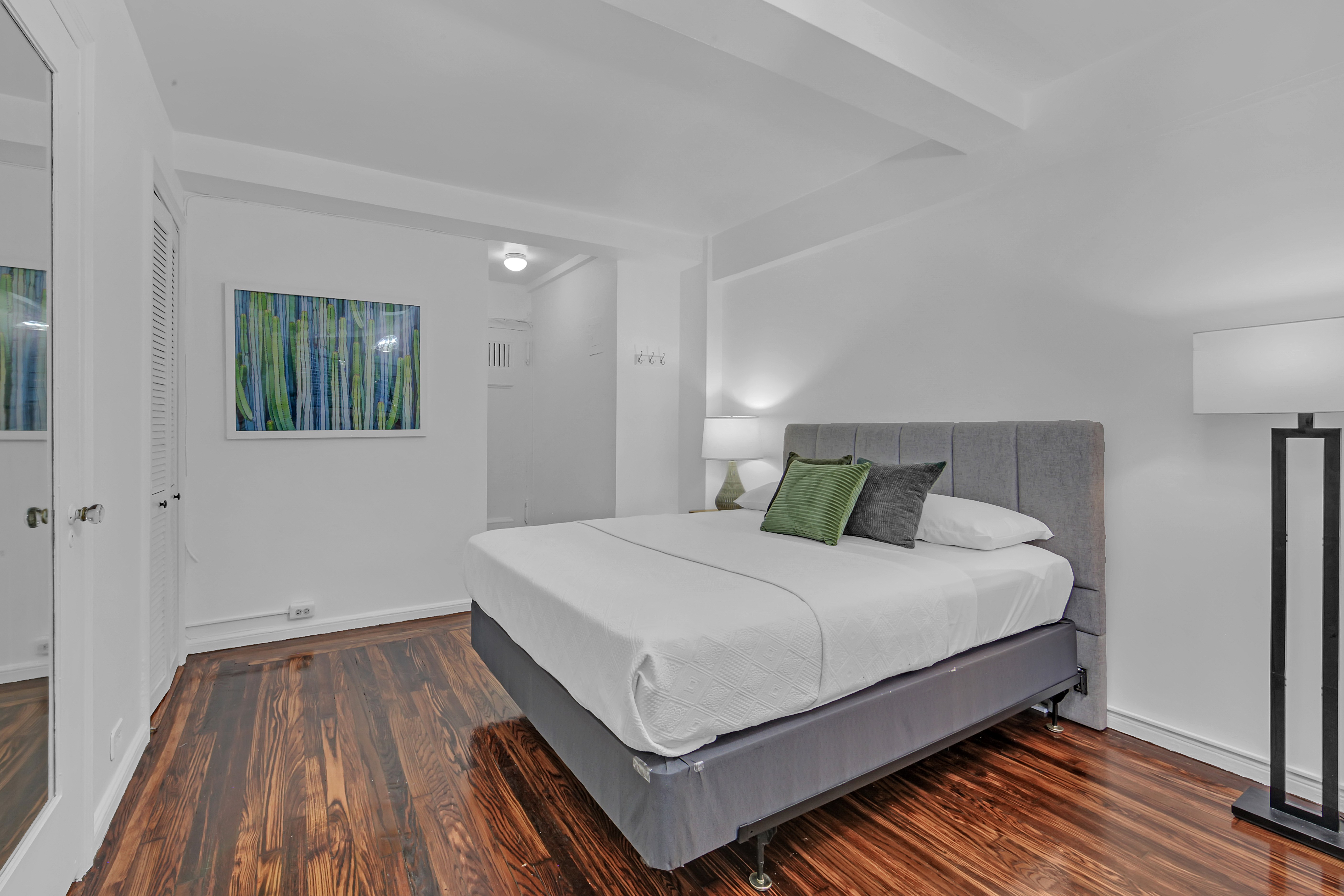 45 Tudor City Place, Unit 1902 Manhattan, NY 10017 - Photo 10 of 19 a bedroom with a bed and wooden floor