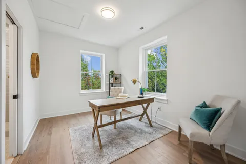 a view of a workspace with furniture and a window