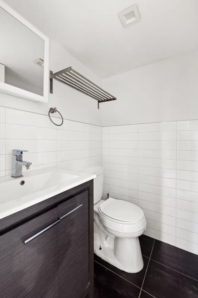 a bathroom with a sink a toilet and a mirror
