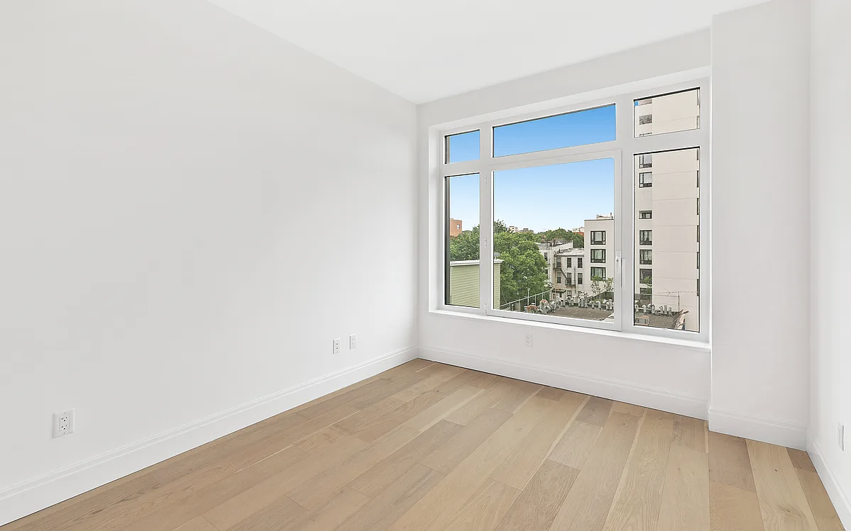 181 18th Street, Unit 408 Brooklyn, NY 11215 - Photo 7 of 13 a view of an empty room with wooden floor and a window