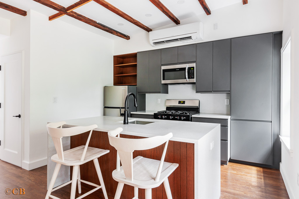221 Gates Avenue, Unit 2 Brooklyn, NY 11238 - Photo 3 of 7 a kitchen with stainless steel appliances granite countertop a stove a refrigerator a microwave oven with white cabinets and wooden floor