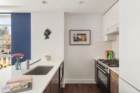 a kitchen with a sink stove and wooden floor
