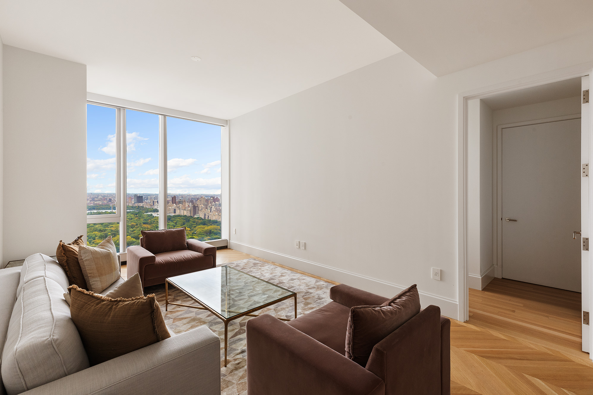 217 West 57th Street, Unit 57N Manhattan, NY 10019 - Photo 2 of 10 a living room with furniture and a floor to ceiling window