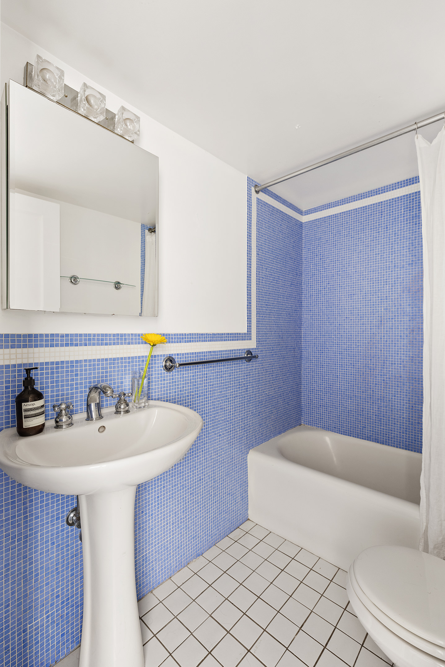 2166 Broadway, Unit 17C Manhattan, NY 10024 - Photo 9 of 11 a bathroom with a sink a toilet and mirror