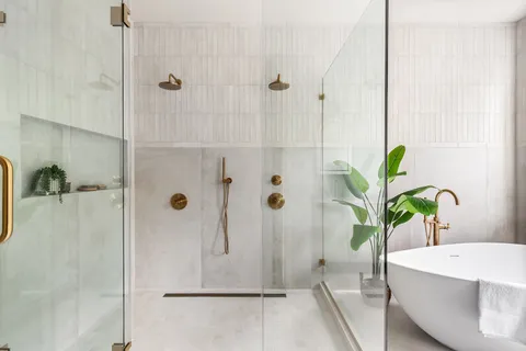 a white bath tub sitting next to a shower