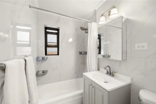 a bathroom with a sink mirror toilet and bathtub