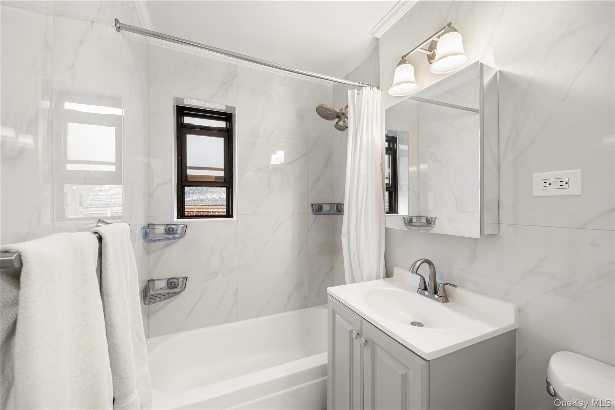 217-14 73rd Avenue, Unit 1 Queens, NY 11364 - Photo 13 of 19 a bathroom with a sink mirror toilet and bathtub