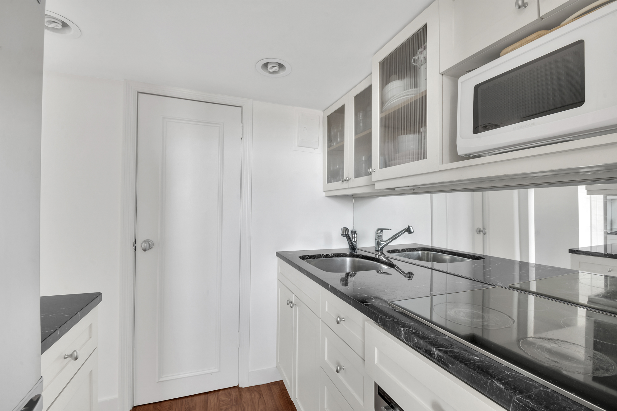 140 West 69th Street, Unit 107A Manhattan, NY 10023 - Photo 7 of 15 a kitchen with stainless steel appliances granite countertop a sink and a microwave