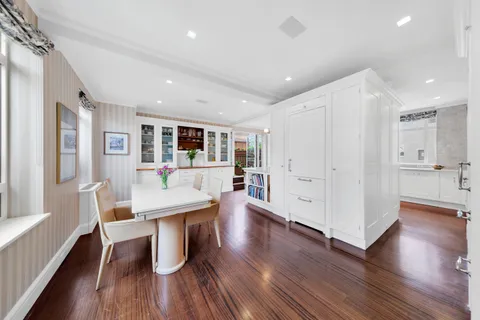 a living room with stainless steel appliances furniture and wooden floor