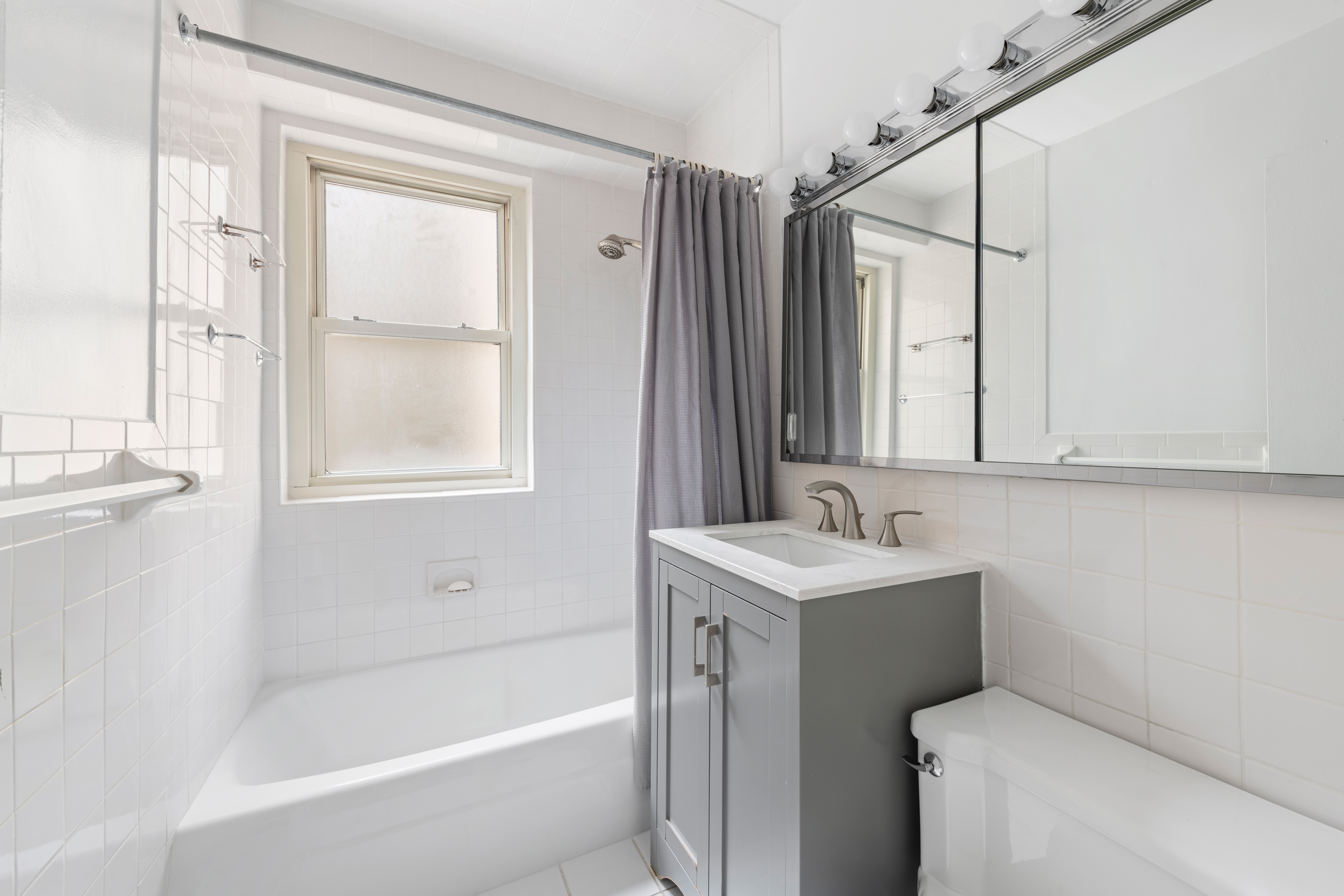 370 East 76th Street, Unit C607 Manhattan, NY 10021 - Photo 10 of 12 a bathroom with a sink toilet vanity and tub