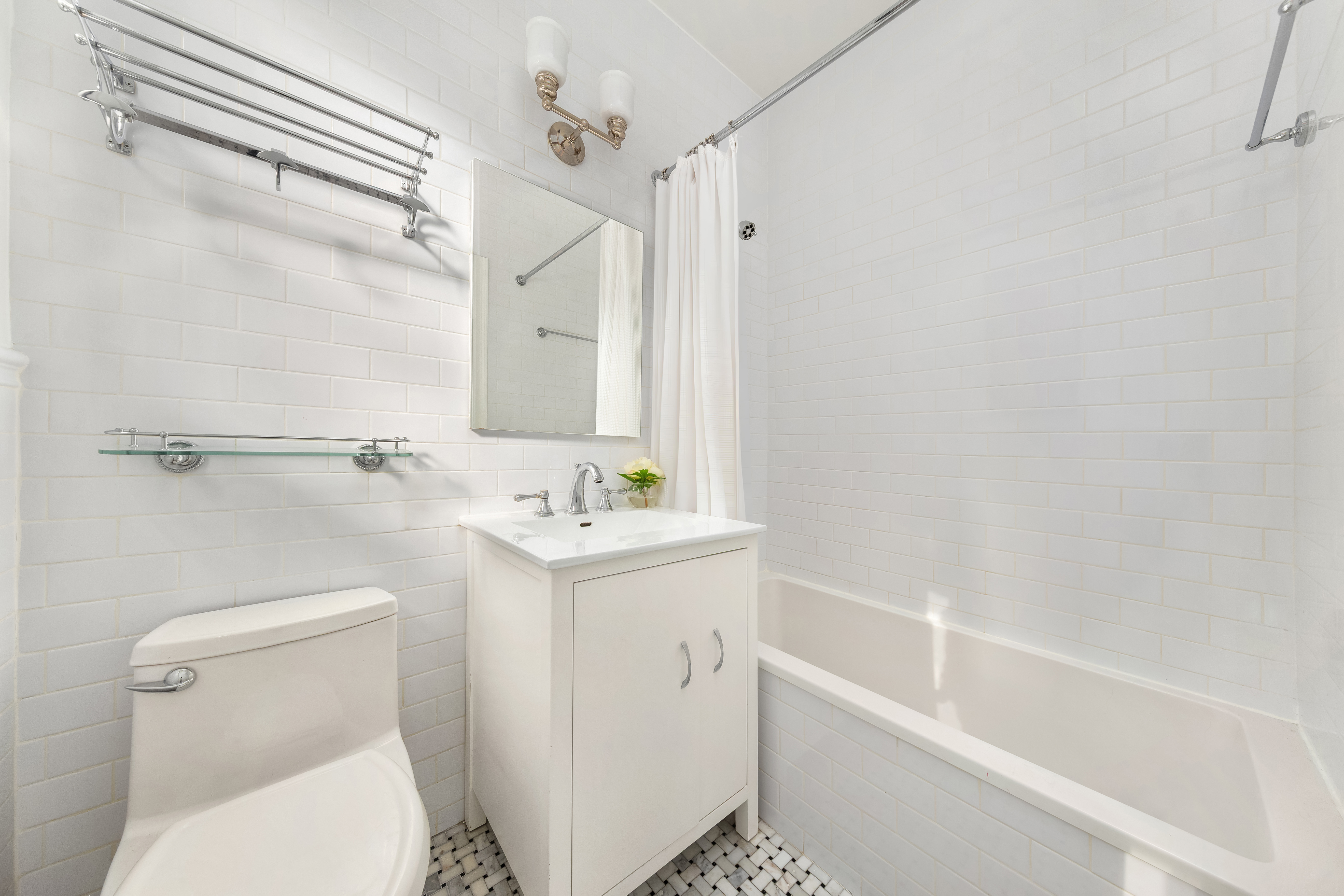 929 Park Avenue, Unit 6C Manhattan, NY 10028 - Photo 4 of 10 a bathroom with a sink a toilet and shower