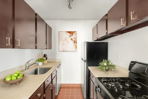 a kitchen with stainless steel appliances a sink a stove a microwave a sink a refrigerator and cabinets