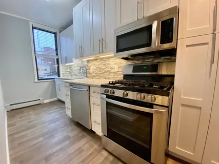 a kitchen with granite countertop wooden cabinets and a stove top oven