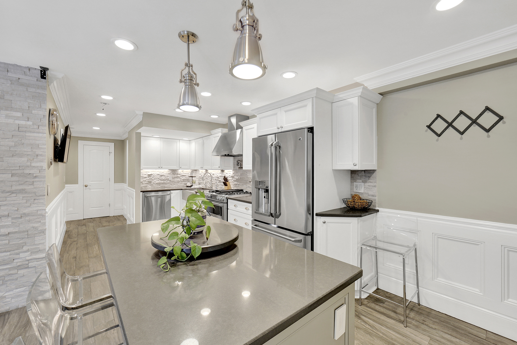 1-69 Beach 98th Street, Unit 1 Queens, NY 11694 - Photo 16 of 23 a kitchen with stainless steel appliances kitchen island granite countertop a sink a stove a refrigerator and cabinets