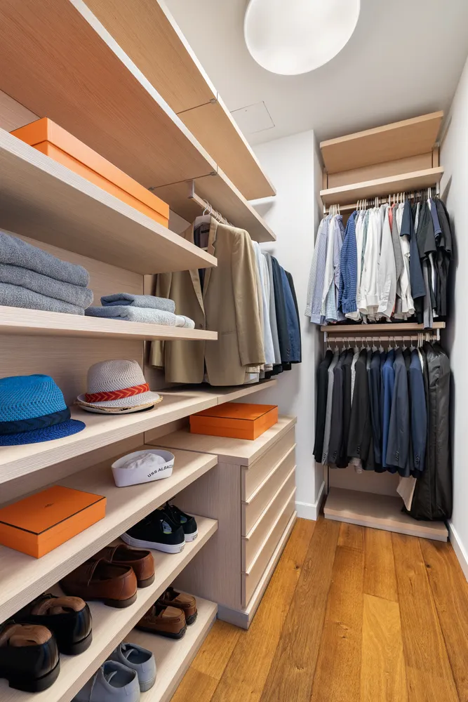 a view of walk in closet with clothes and shoes