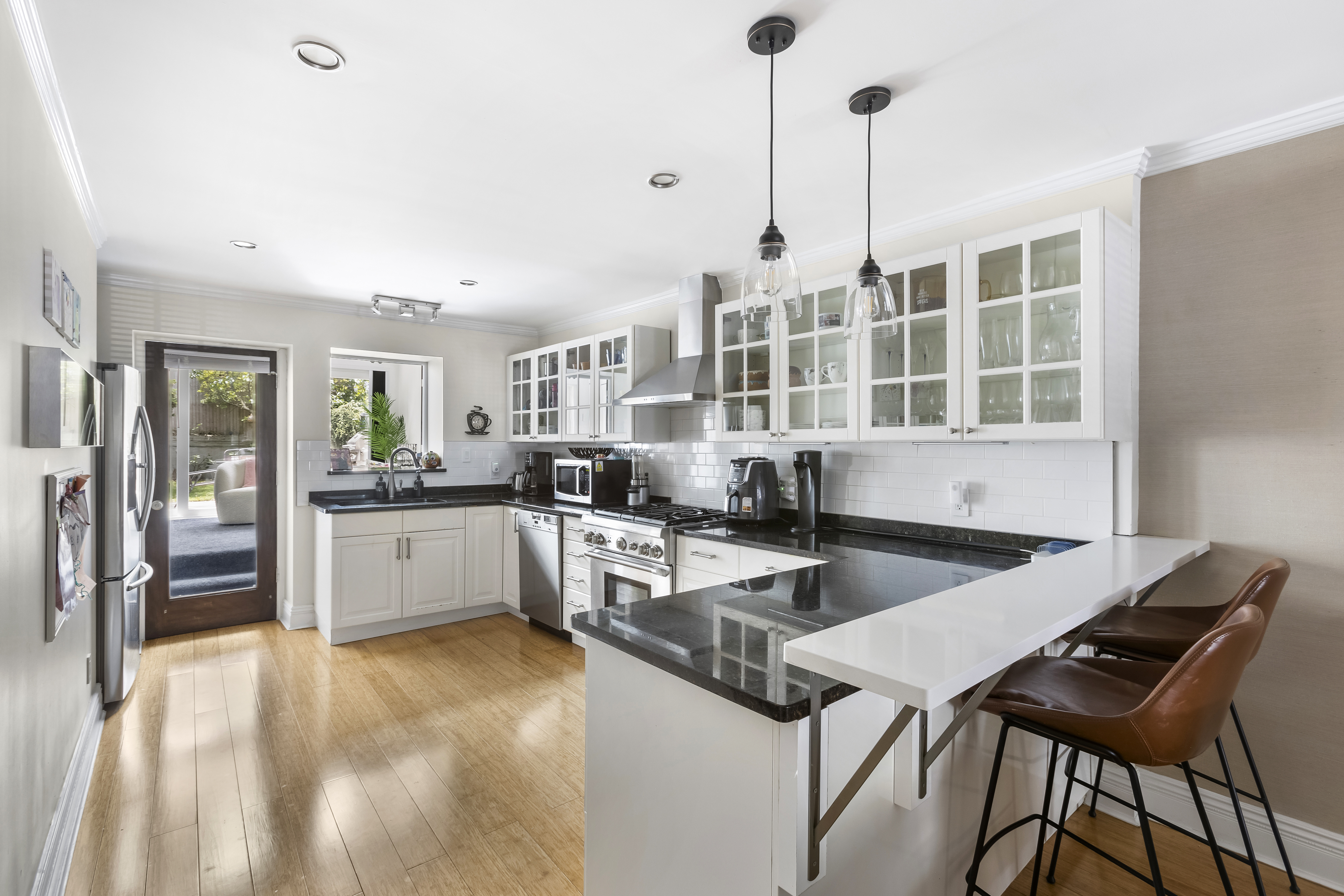 312 10th Street Brooklyn, NY 11215 - Photo 8 of 17 a kitchen with granite countertop a table chairs stove and cabinets