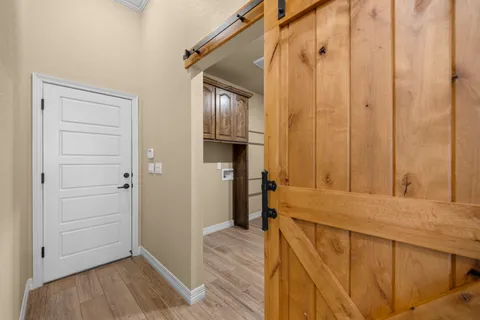 a view of an empty room with window and wooden floor