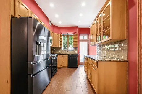 a kitchen with stainless steel appliances granite countertop a refrigerator and a stove