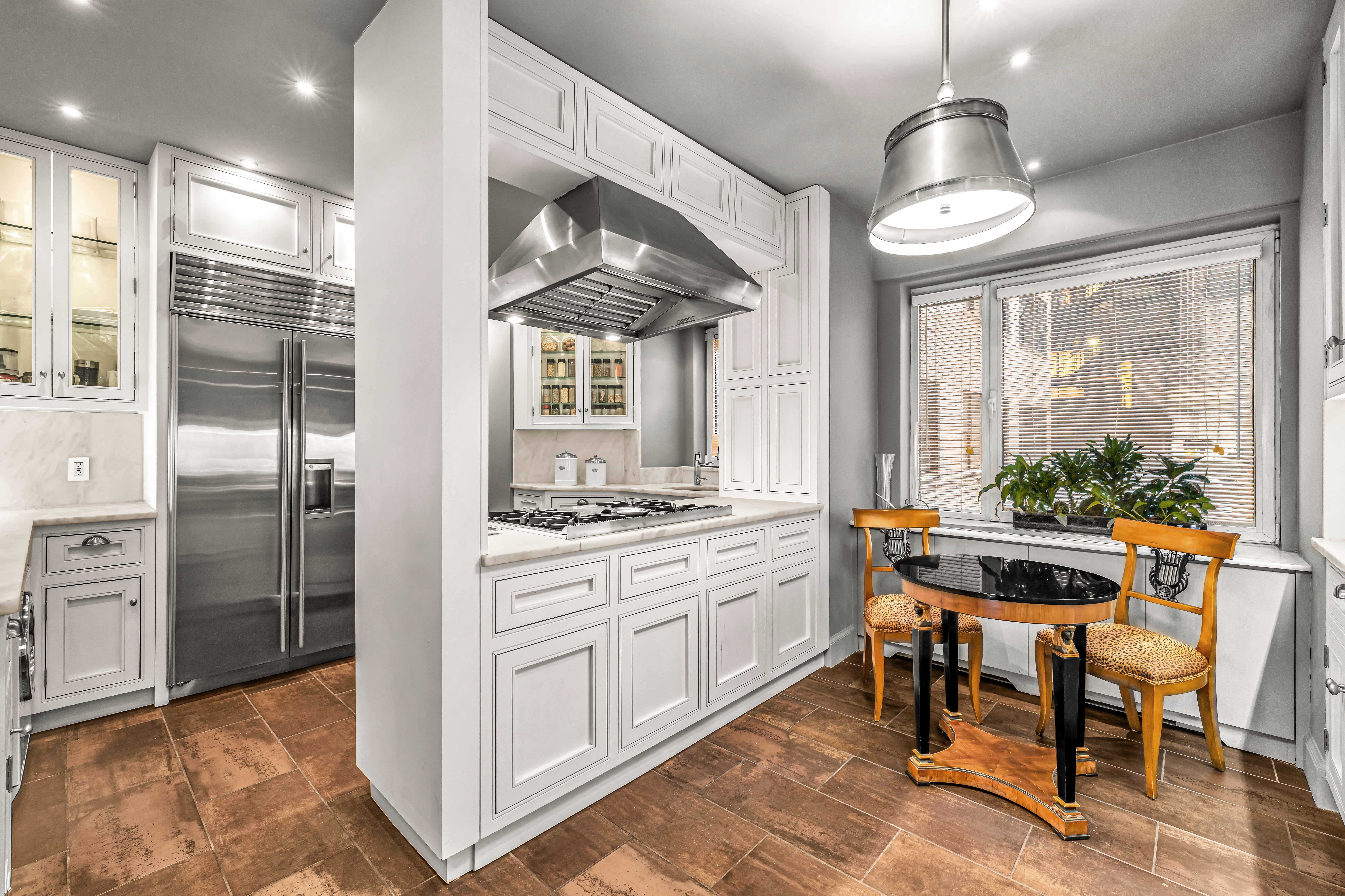 785 5th Avenue, Unit 3C Manhattan, NY 10022 - Photo 6 of 16 a kitchen with stainless steel appliances granite countertop a stove and a refrigerator