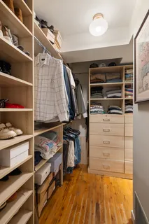 a view of walk in closet with clothes and shoes